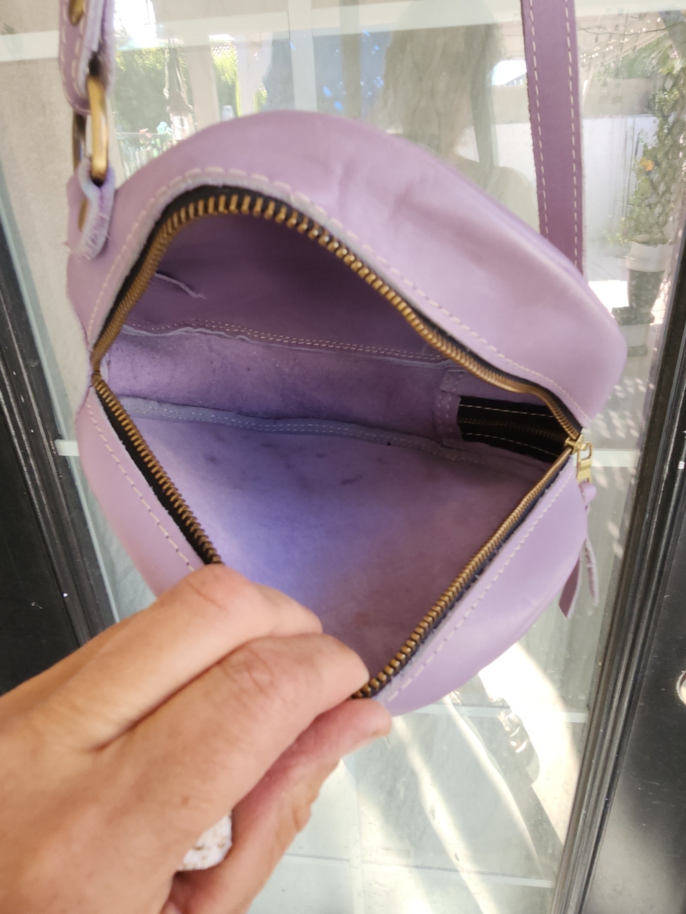 The purple round bag in the image is a Circle Crossbody in the color Lavender - Picture 8 of 8